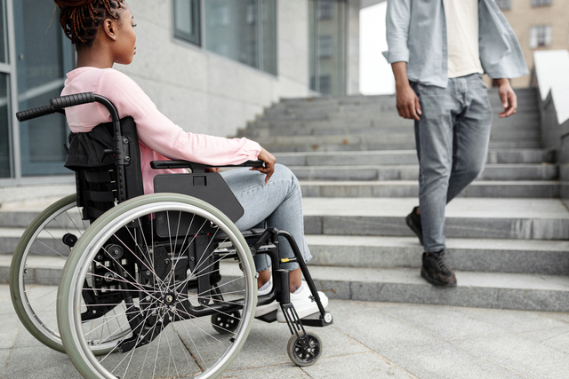 Young black disabled woman suffering from lack of wheelchair friendly facilities, cannot get home without ramp